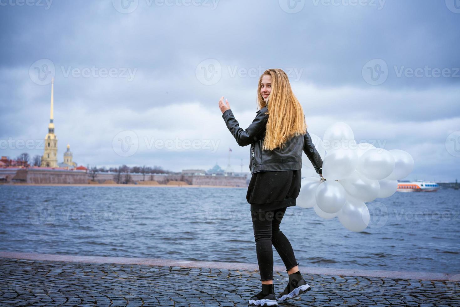 glad tjej leker med ballonger utomhus hoppar av lycka foto