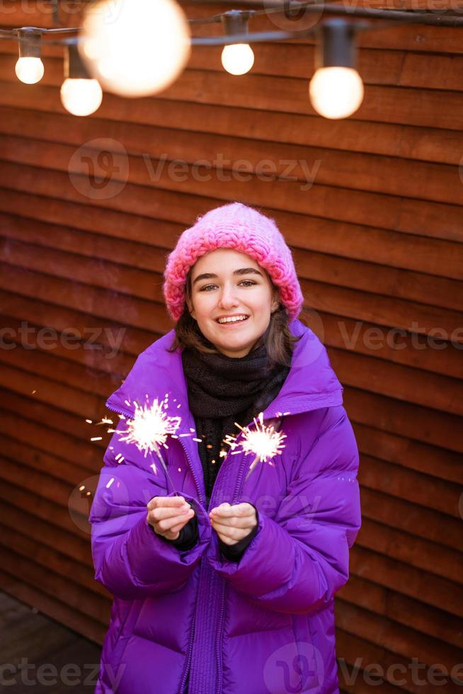porträtt av ung kvinna i puff med tomtebloss i händerna ler söt foto
