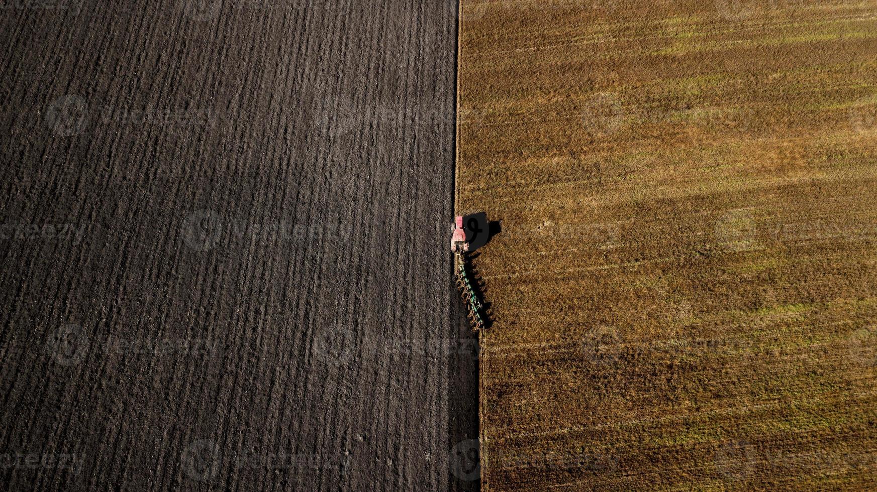 traktor som plöjer fältet foto