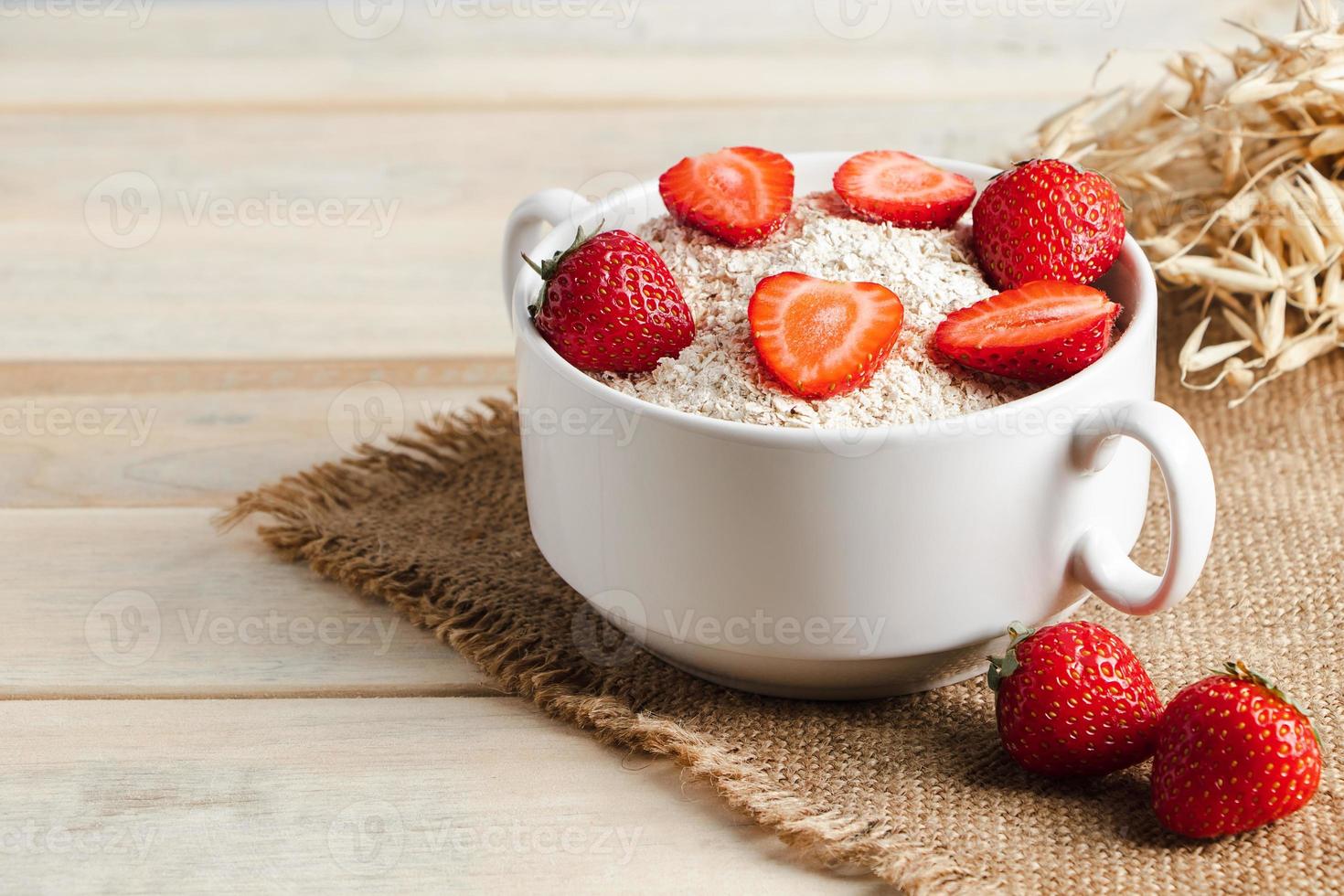 havre müsli och färska jordgubbar på trä bakgrund. foto