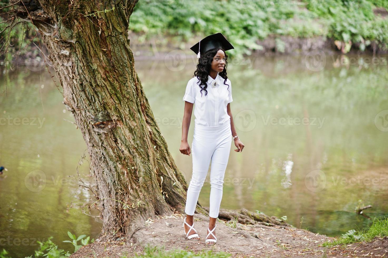 glad vacker svart afrikansk amerikansk tjej med hatt akademiker foto