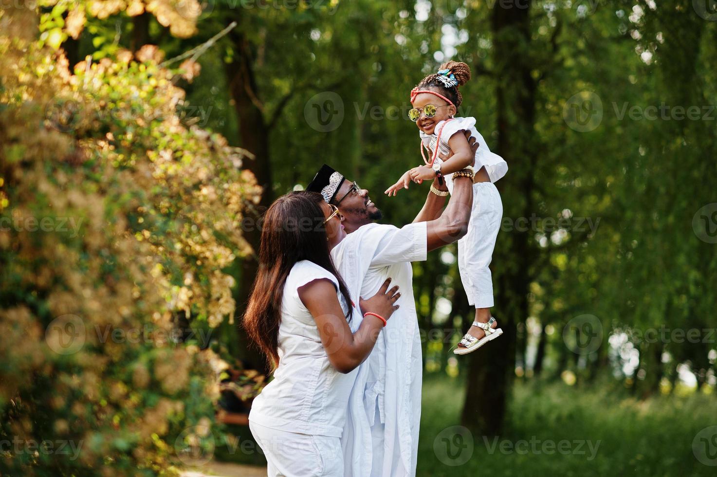 afroamerikansk rik familj som har kul på solnedgången. far kastar dotter på händerna foto