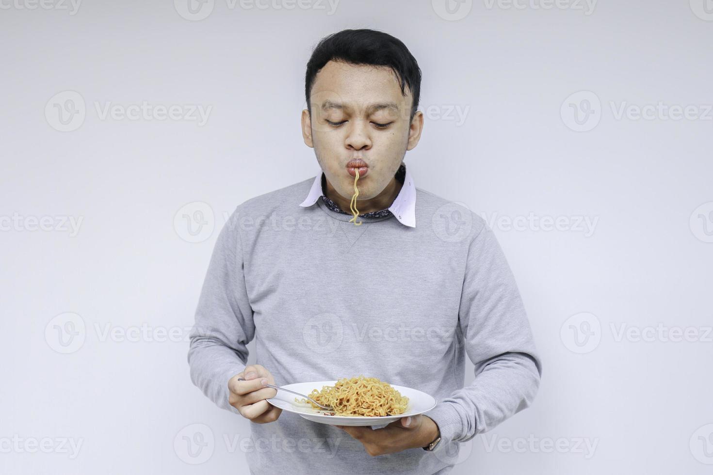 ung asiatisk man njuta av nudlar. äta lunch koncept. foto