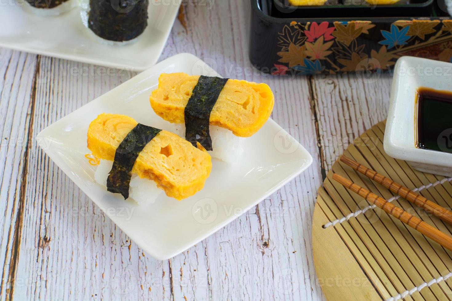 tamagoyaki sushi eller sött ägg på ris och tång wrap på fyrkantig vit tallrik. utsökt japansk mat. foto