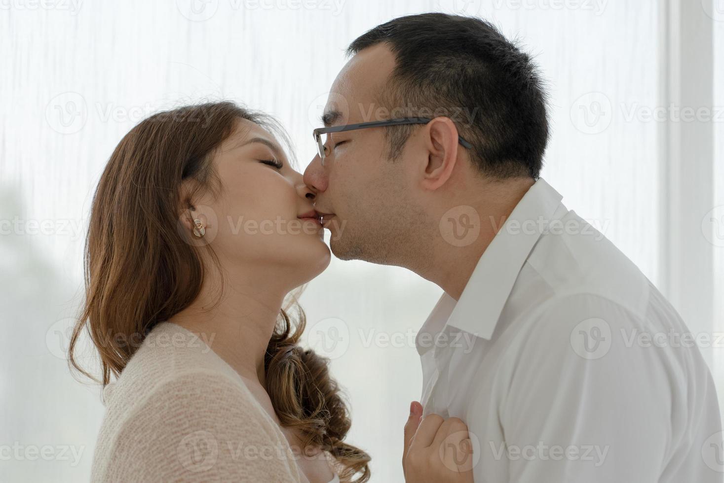 porträtt av asiatisk man kysser kvinna foto
