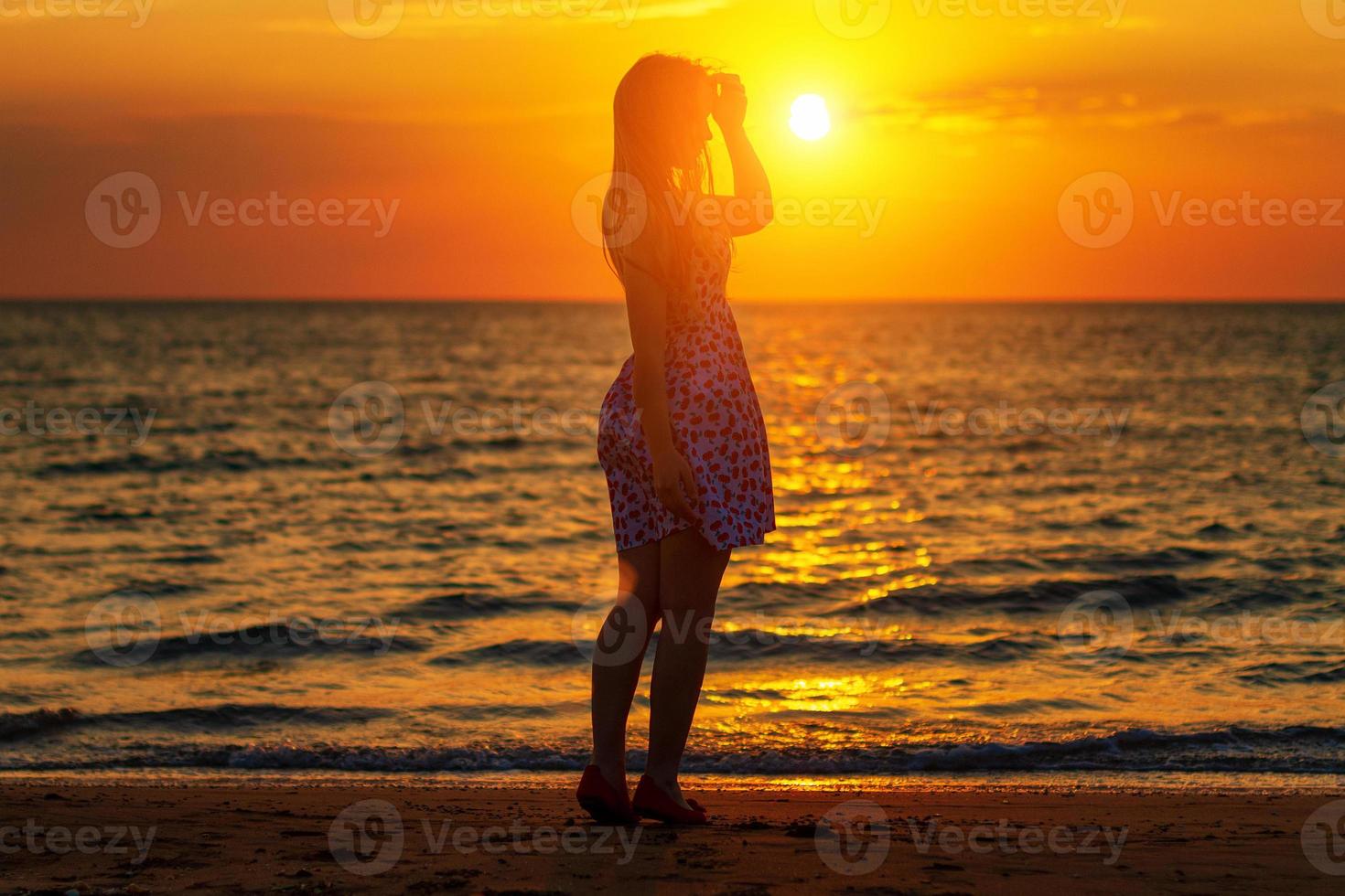 siluett vid solnedgången flicka på stranden, kvällspromenader på kusten foto