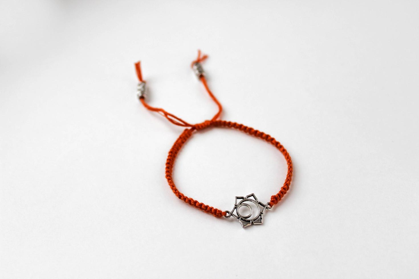 orange flätat armband med chakra svadhishthana på vit bakgrund foto