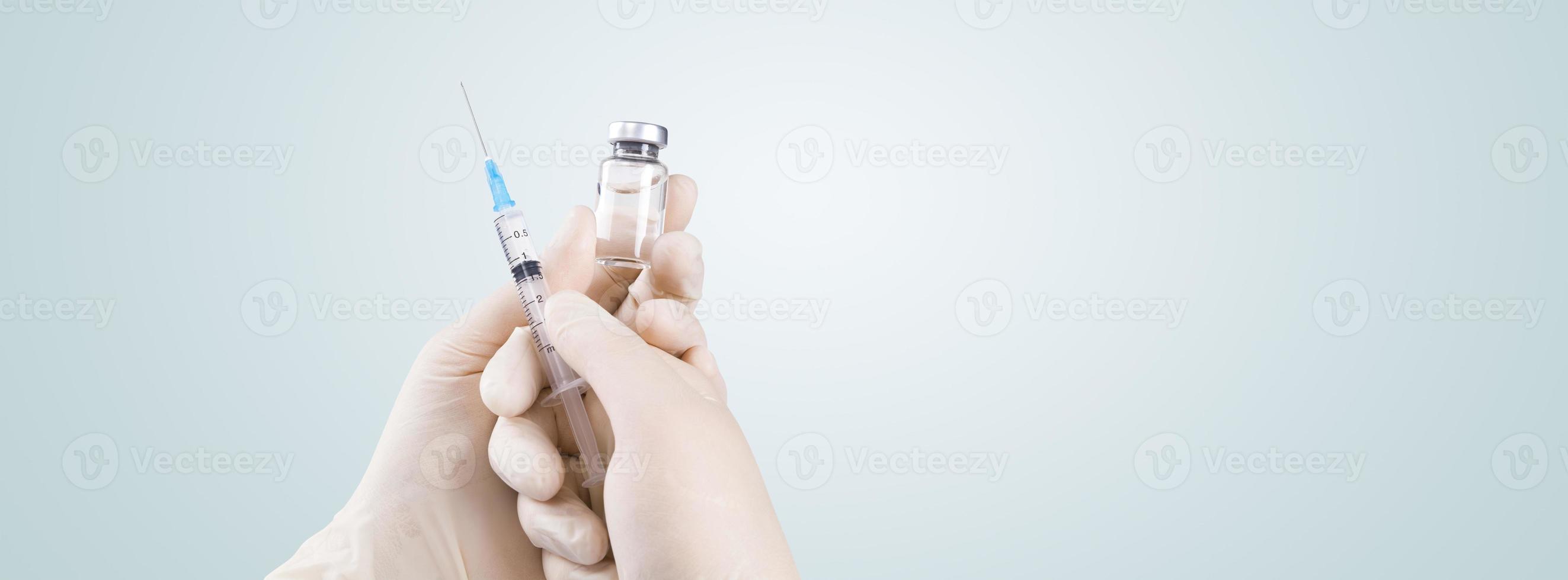 hand som håller spruta med vaccin mot coronavirus. foto