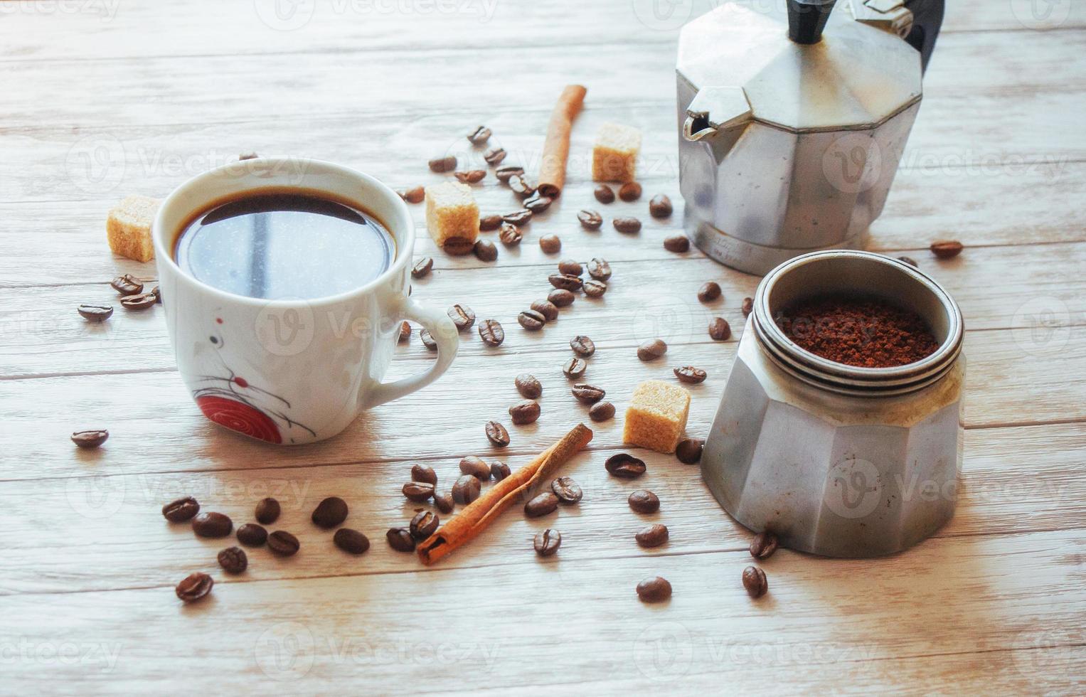 kaffebönor och kopp kaffe på bordet på bakgrunden foto