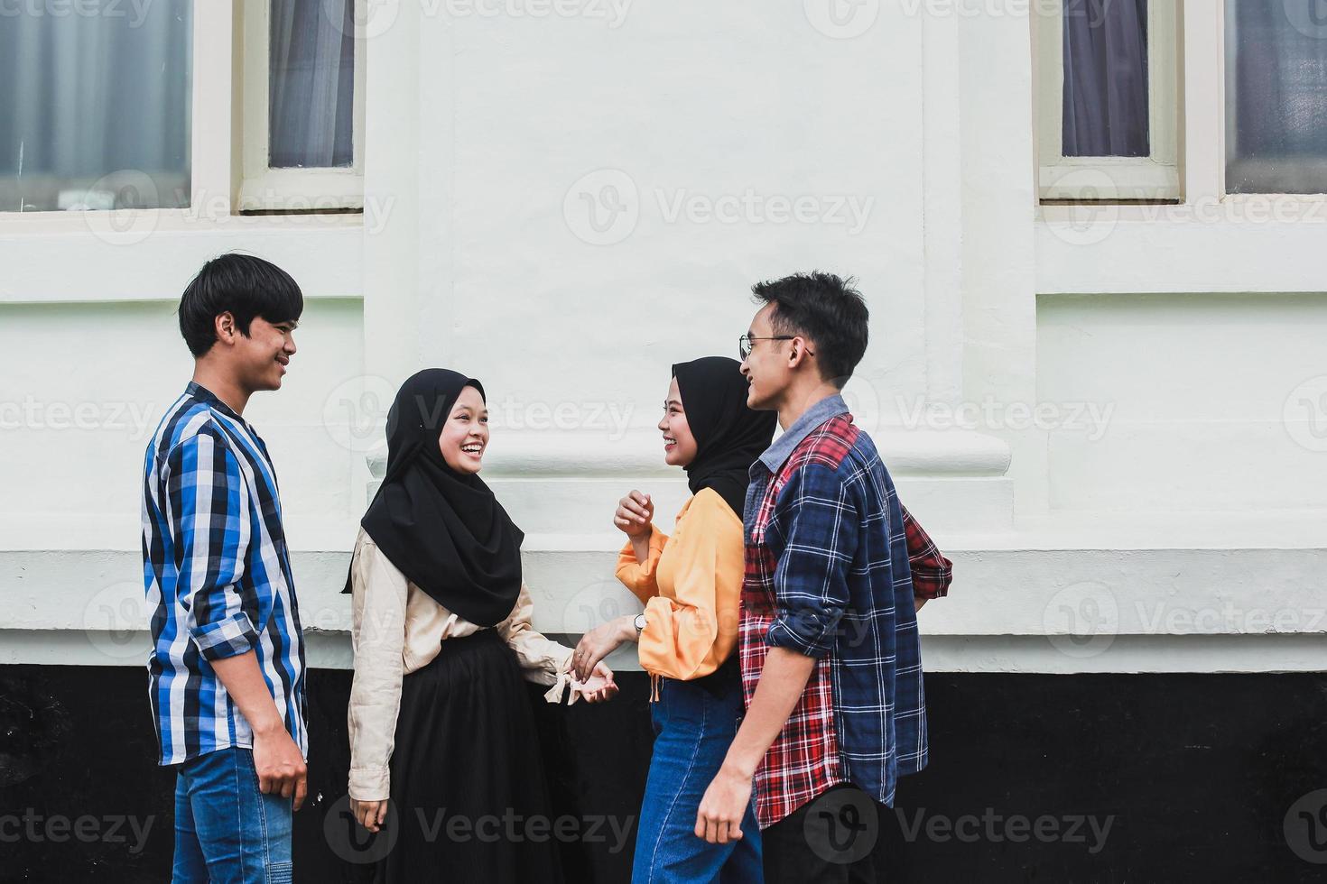 grupp asiatiska ungdomar som ler och pratar tillsammans foto