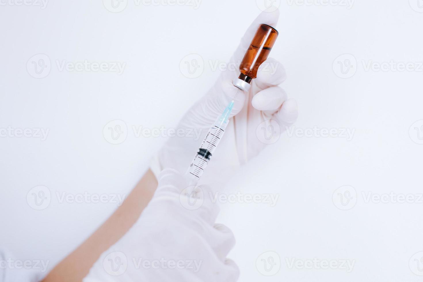 hand av läkare med gummihandskar fylla sprutan med medicin. vaccination och immunisering foto