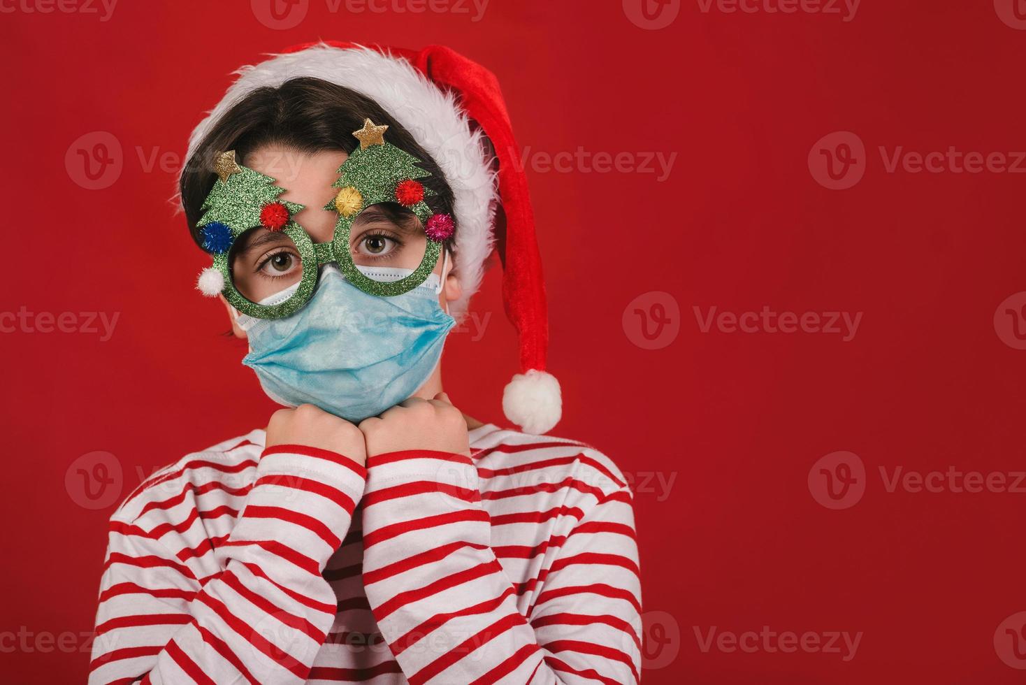 god jul, barn med medicinsk mask och roliga julglasögon foto
