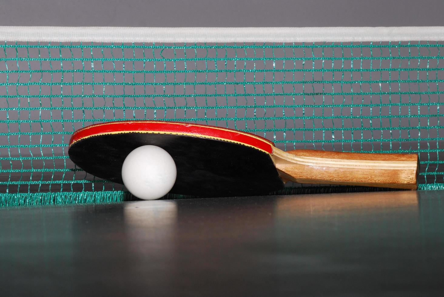 bordtennisracket med boll och nät närbild foto