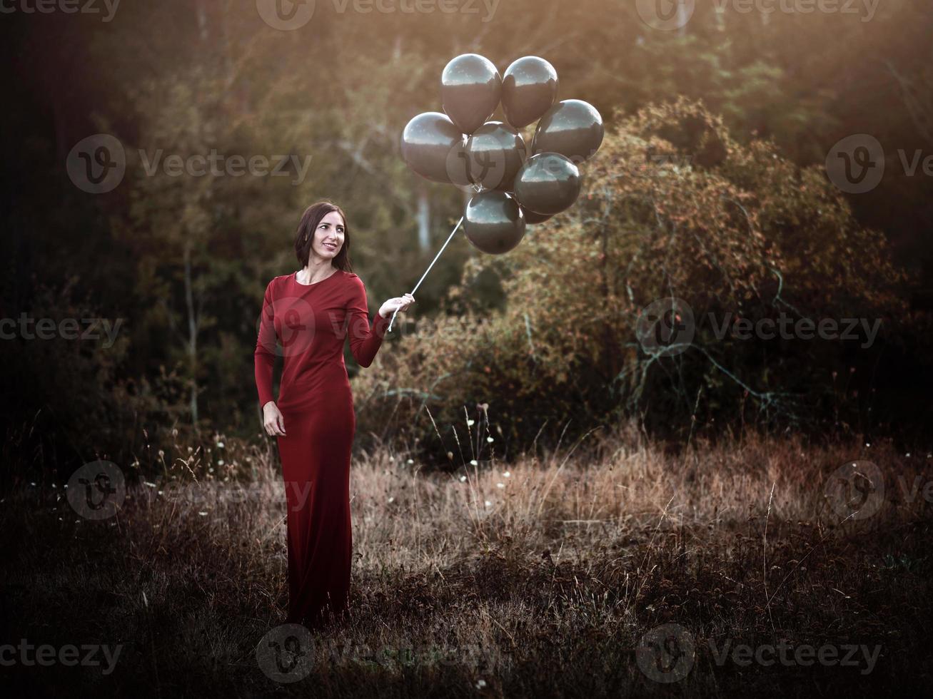 leende kvinna med ballonger i fältet foto