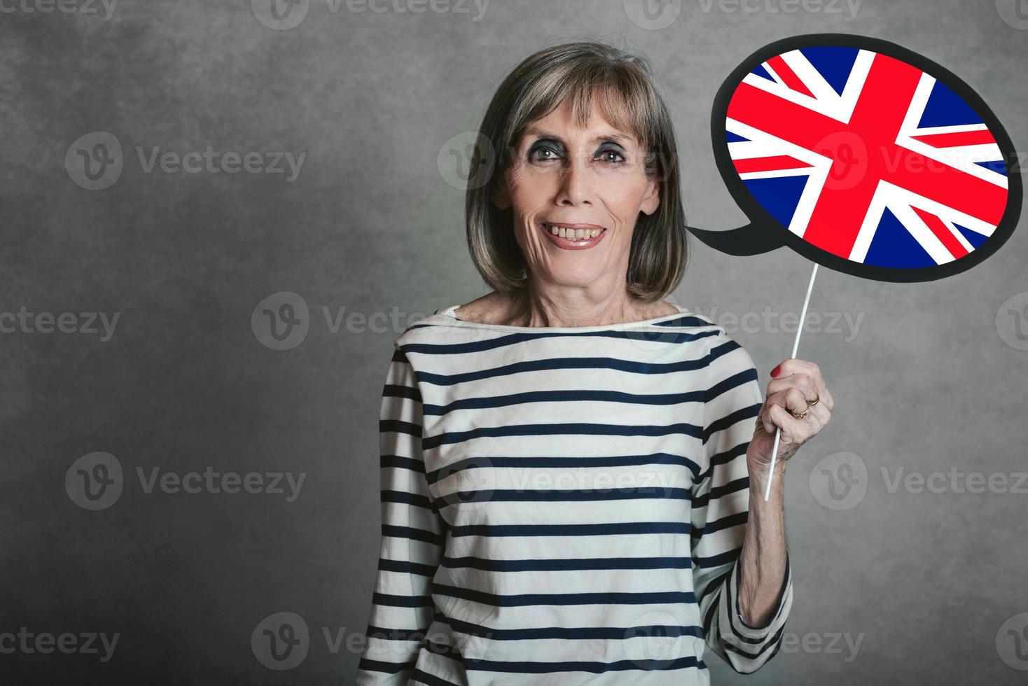 senior kvinna som håller en skylt med den engelska flaggan foto