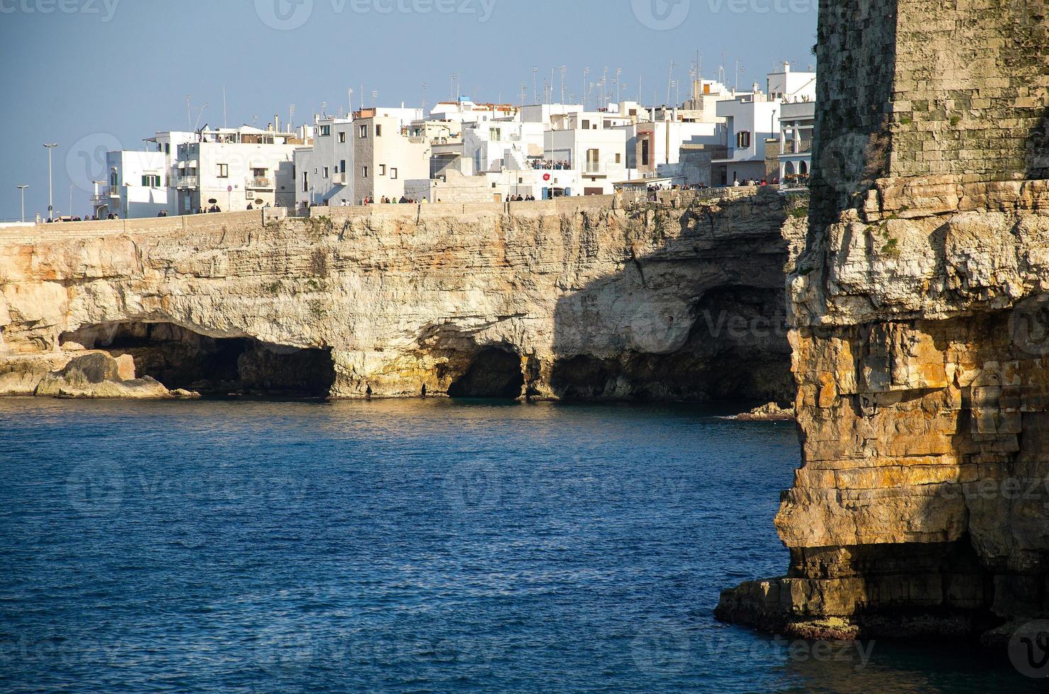 vita byggnader på grottor och klippor i staden Polignano ett sto i Puglia foto