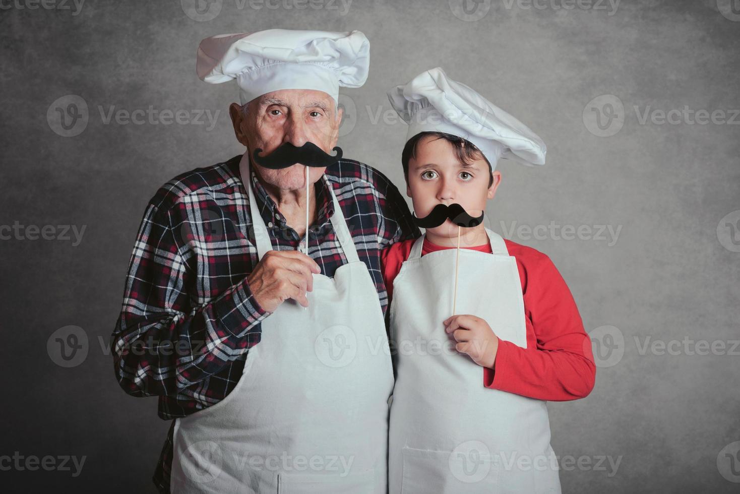 farfar med barnbarn med kockhatt och mustasch foto