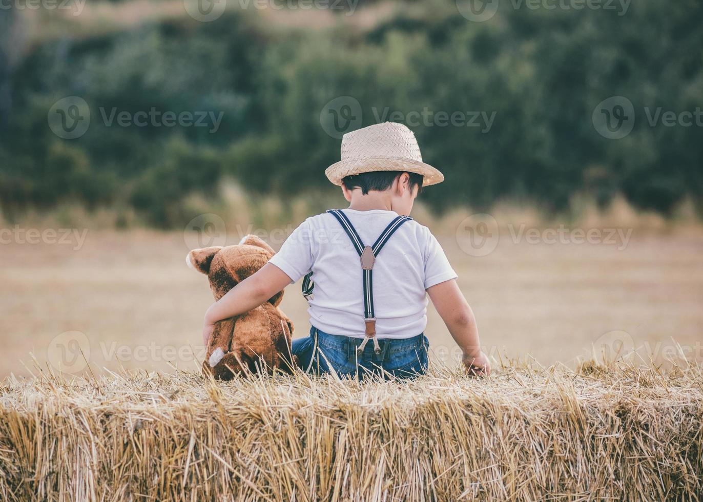 pojke kramar nalle i vetefältet foto