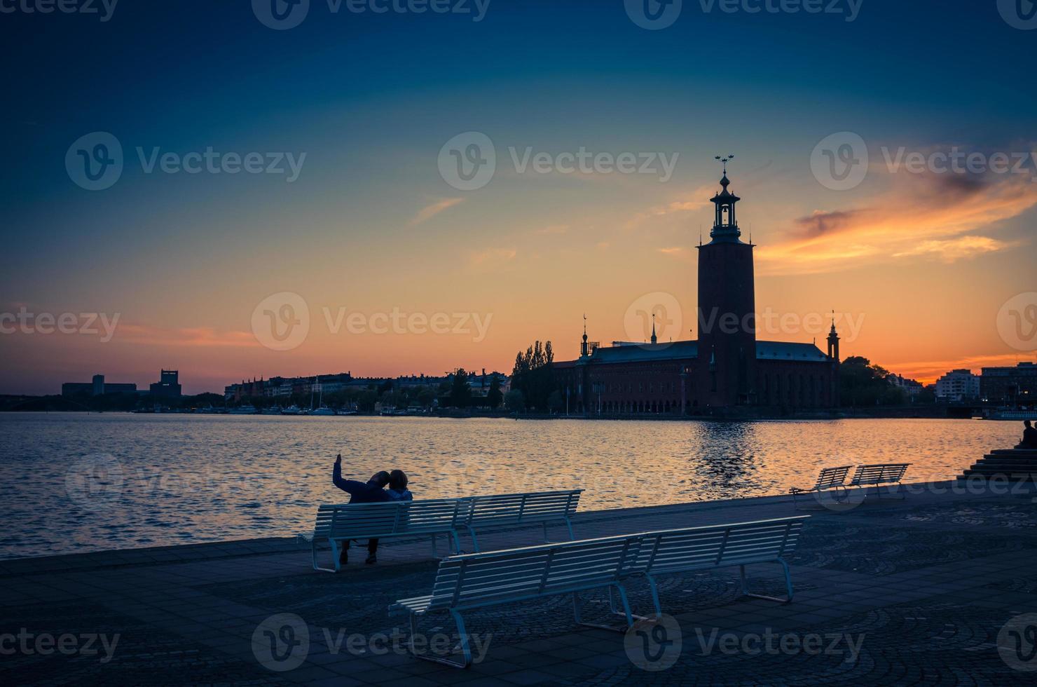 siluett av man och kvinna som sitter på bänken, stockholm, sverige foto