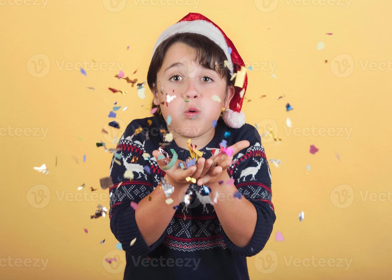 barn blåser konfetti bär jultomten hatt foto