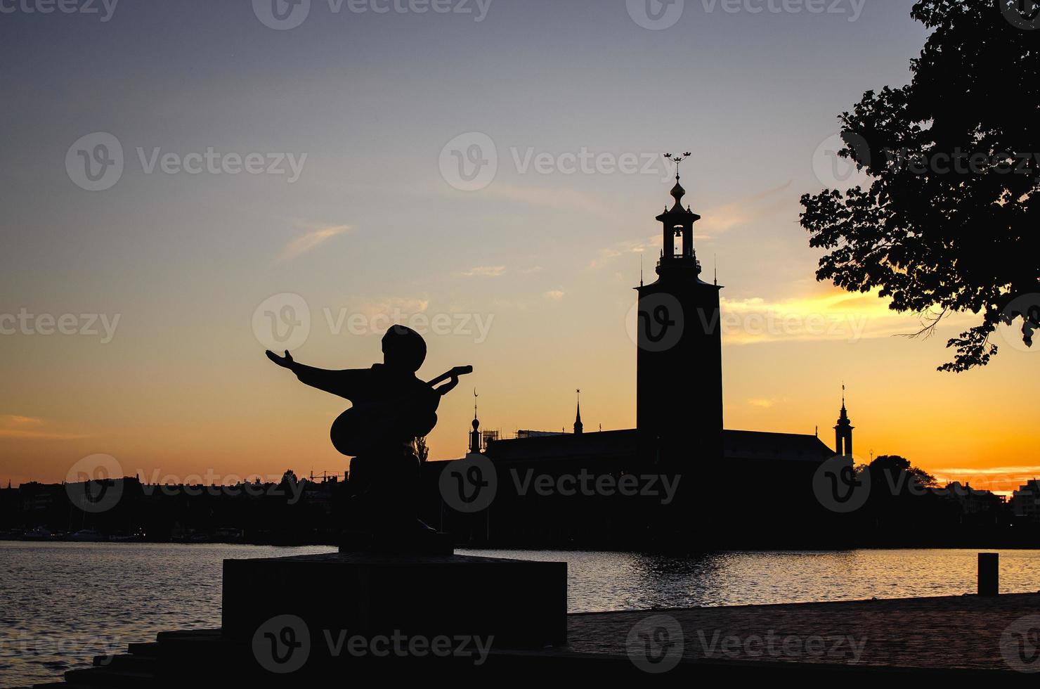siluett av evert taube staty och stockholms stadshus, sverige foto