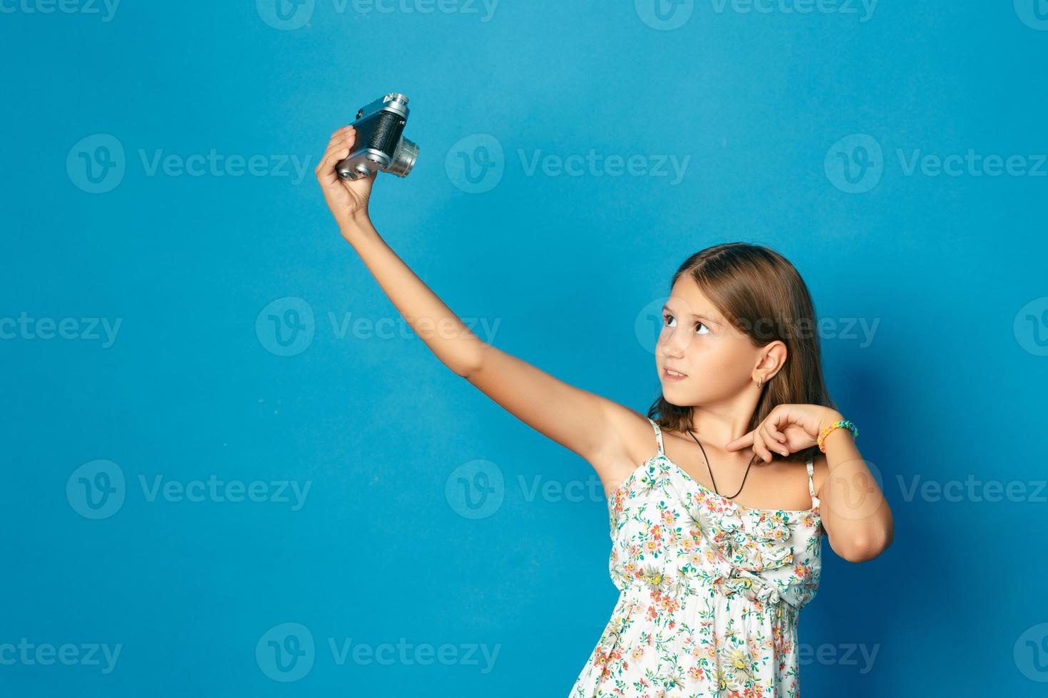 vacker leende tjej med vita tänder som håller en kamera och gör selfie foto