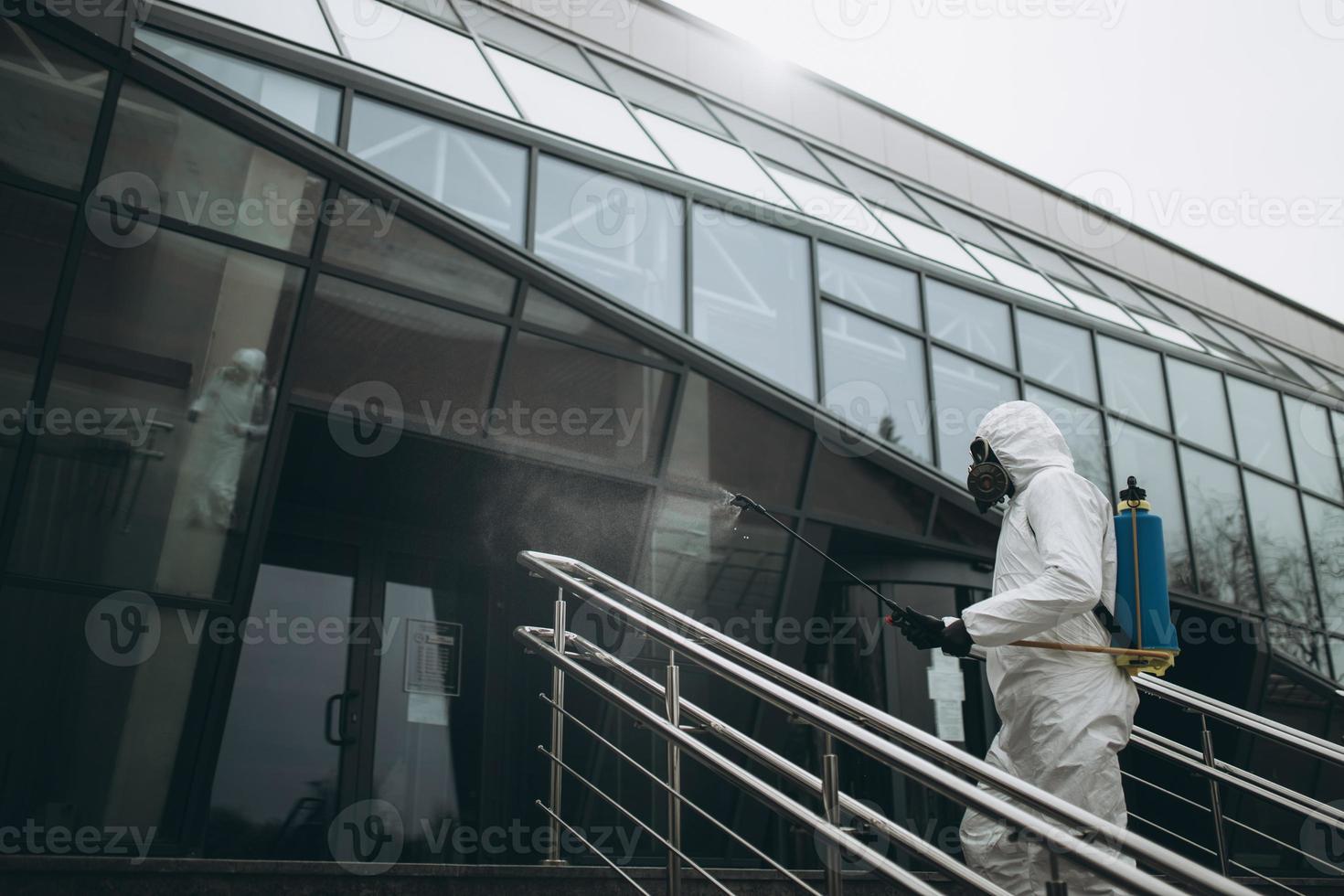 rengöring och desinfektion på stadskomplex mitt i coronaepidemin professionella team för desinfektionsinsatser infektionsförebyggande och kontroll av epidemiskyddsdräkt och mask foto