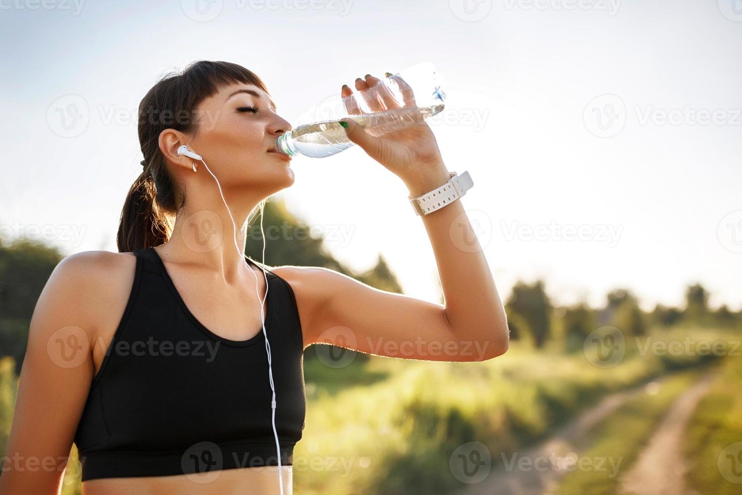 sportig ung kvinna dricksvatten foto
