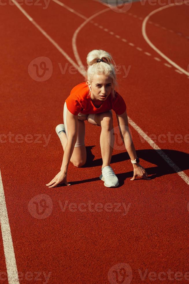 vacker ung blondin gör sig redo att springa foto