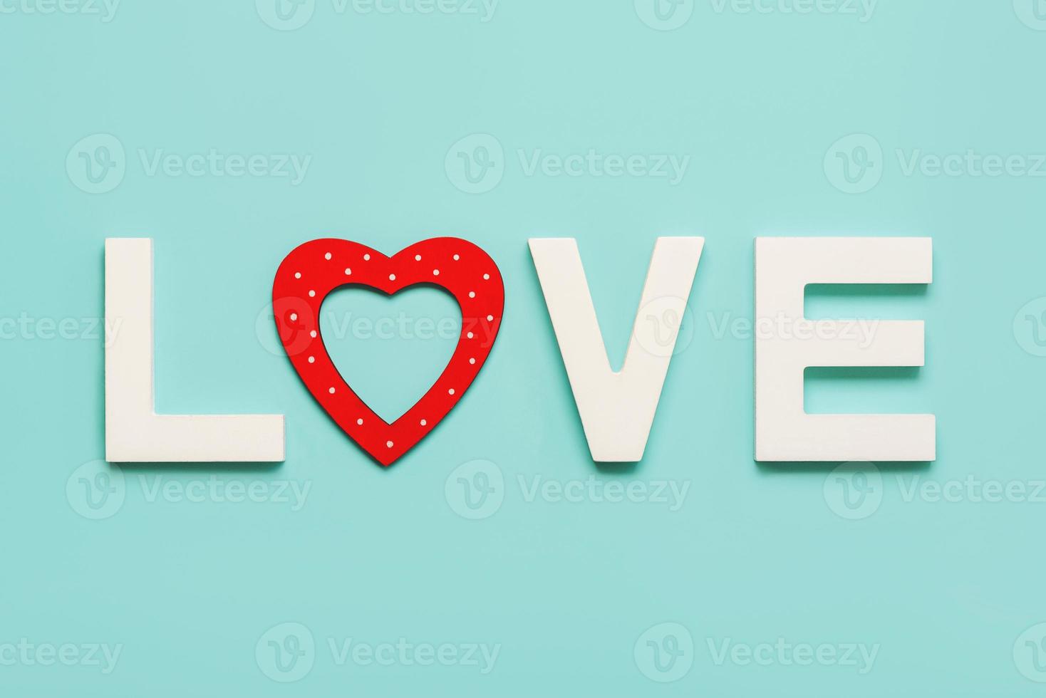 glad alla hjärtans dag. ordet kärlek i vitt trä med ett rött hjärta. alla hjärtans dag firande koncept foto