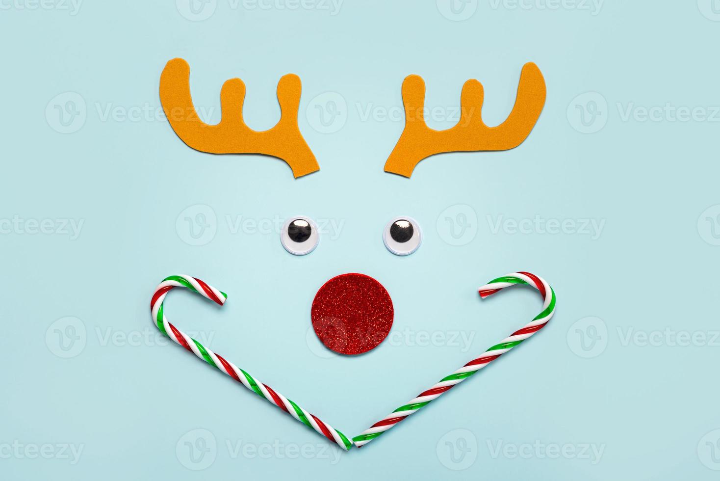 god Jul. christmas rudolph renhorn med lösögon och randiga godisrör. jul koncept bakgrund foto