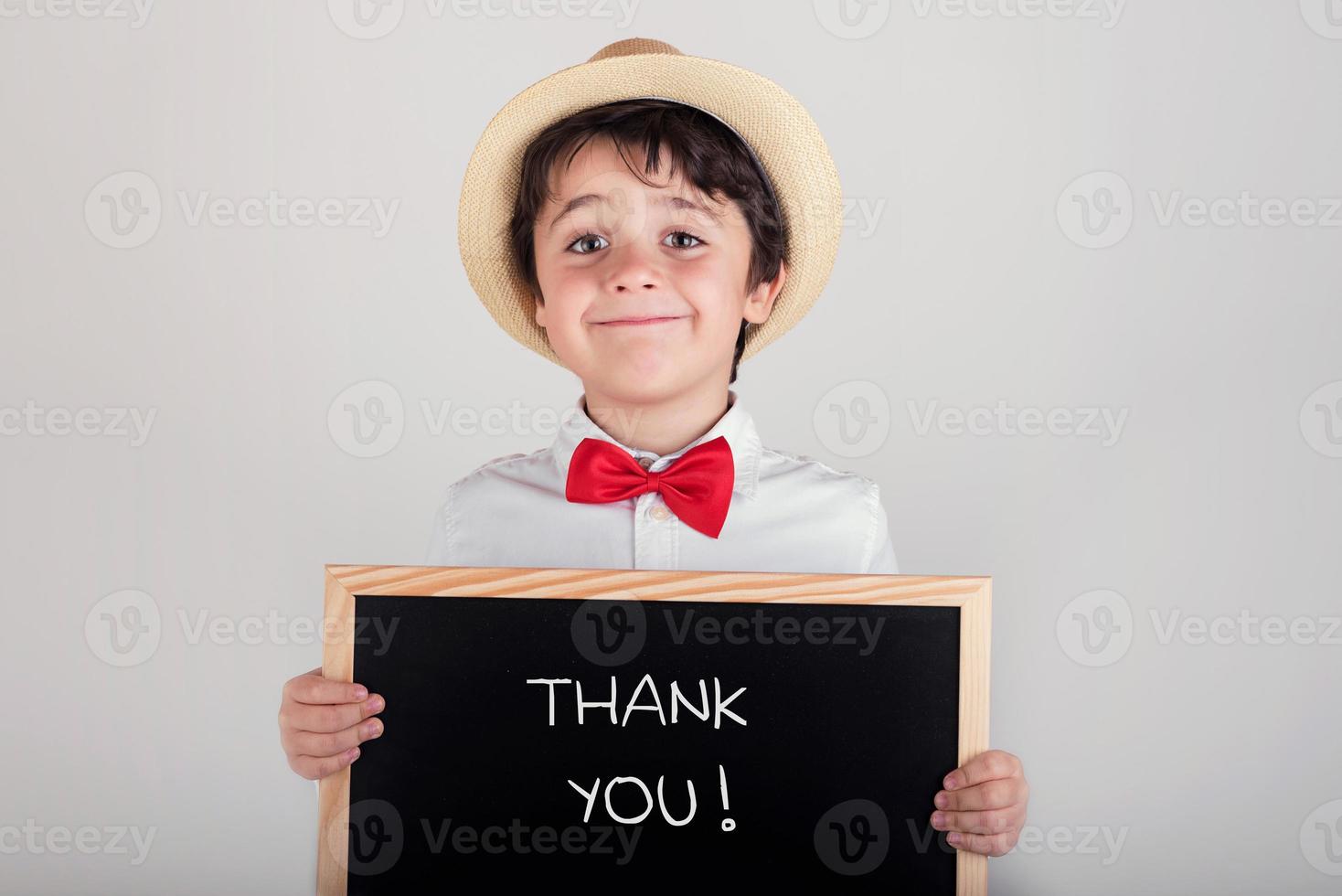 tack, glad pojke med en svart tavla foto