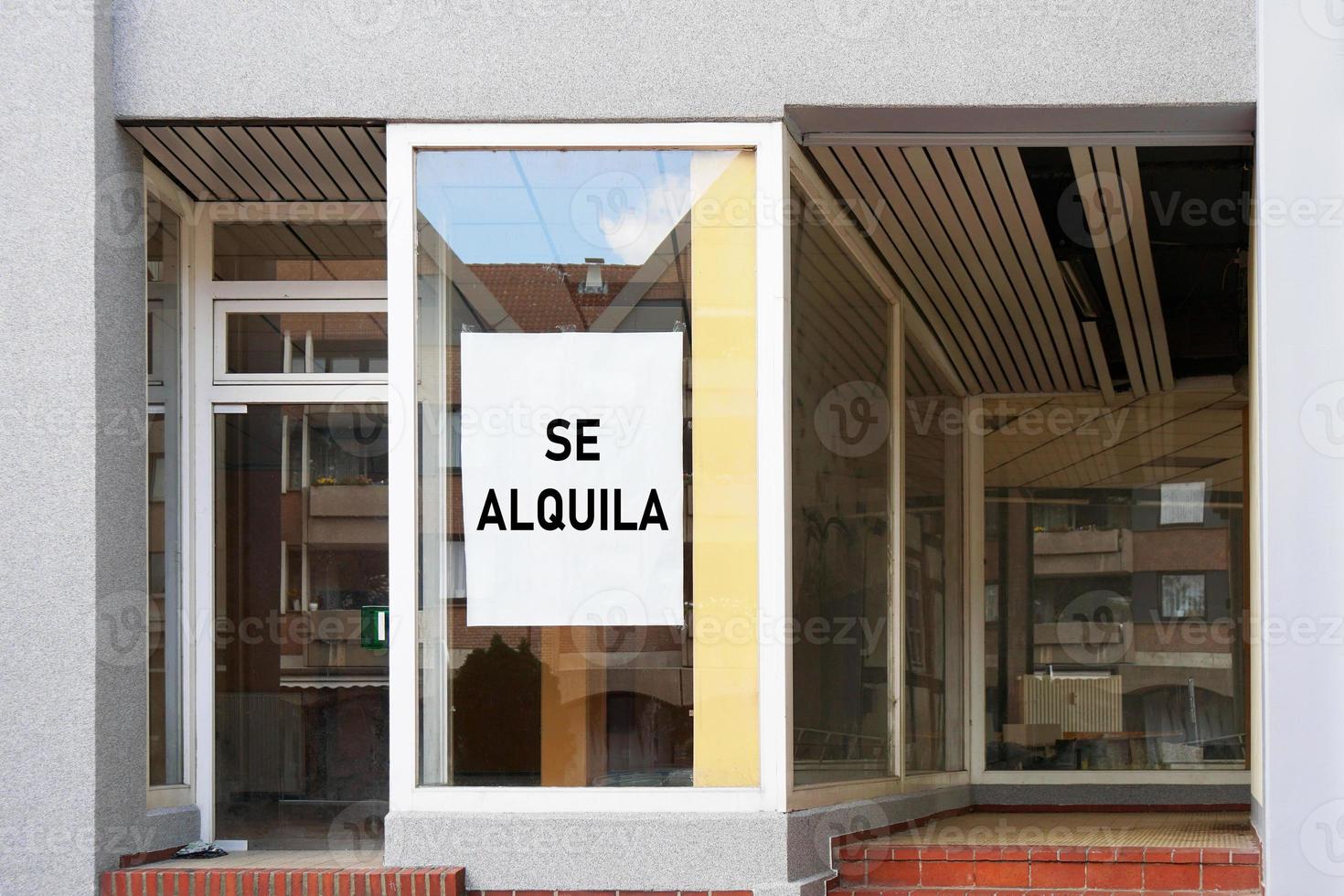 Spansk ledig tjänst skylt i tomt skyltfönster läser se alquila som betyder att hyra foto