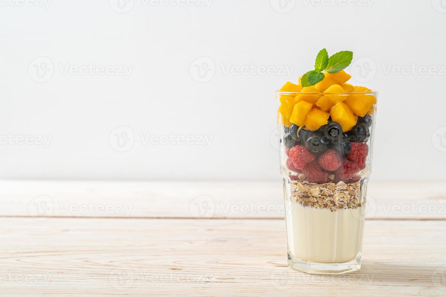 hemlagad mango, hallon och blåbär med yoghurt och granola foto