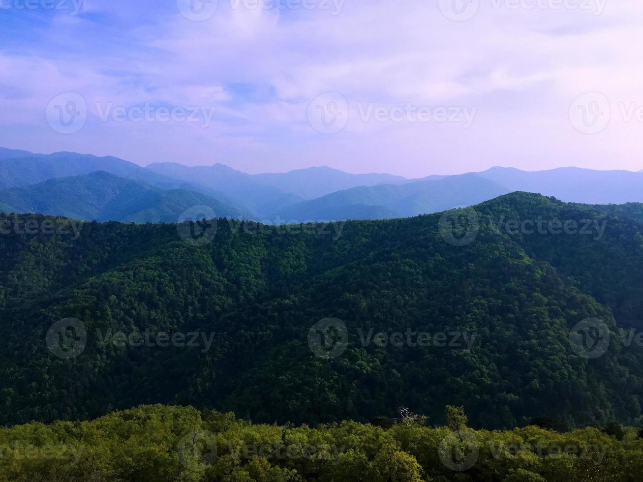 blå himmel vita moln på kullen, skogsbacke naturlandskap foto