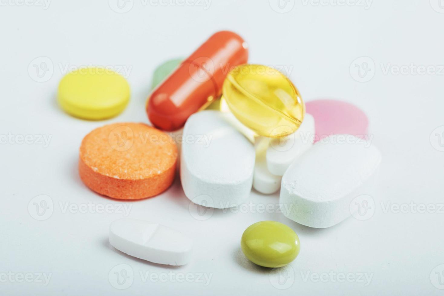 medicinska färgglada piller, kapslar eller kosttillskott för behandling och hälsovård på en ljus bakgrund foto