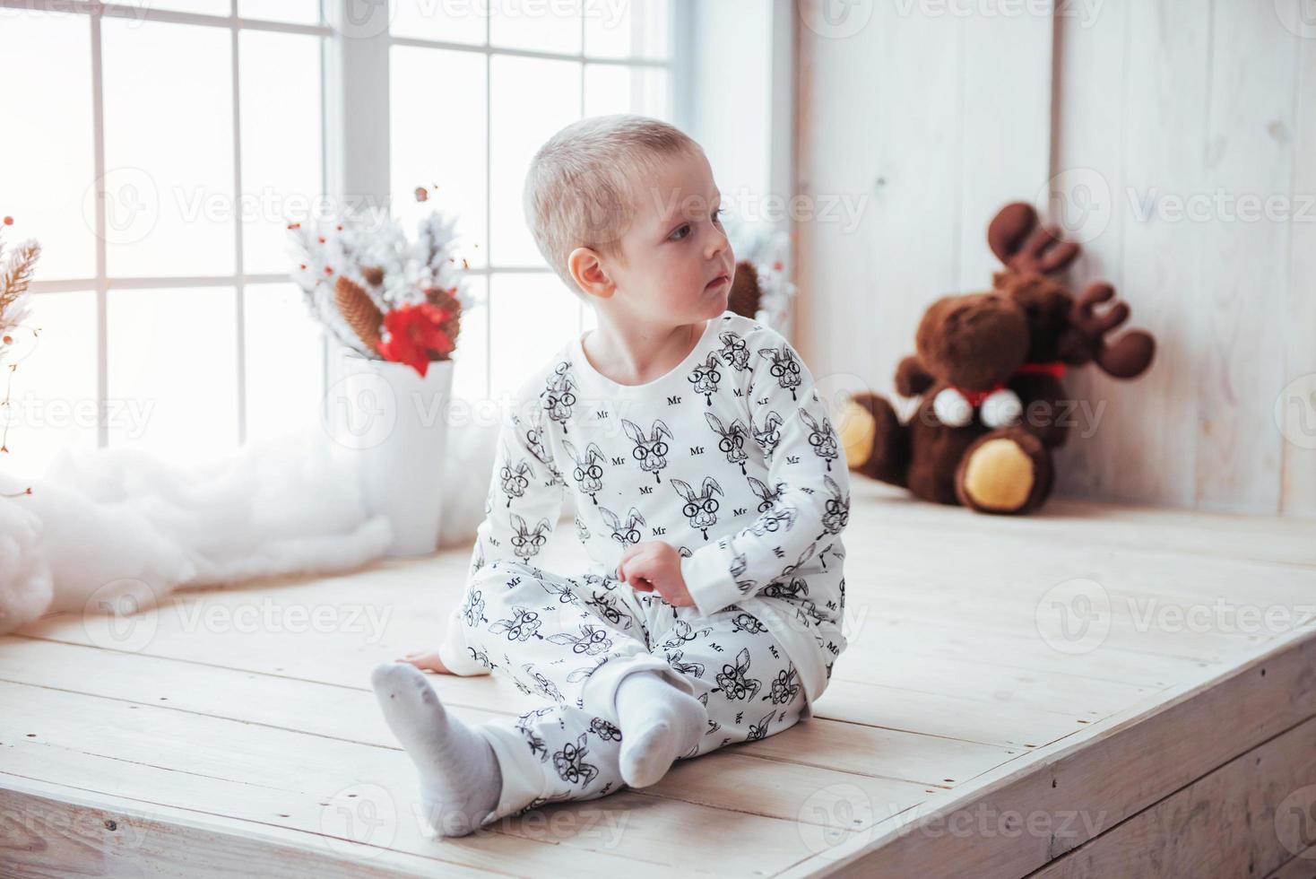 barn i mjuk varm pyjamas som leker i sängen foto