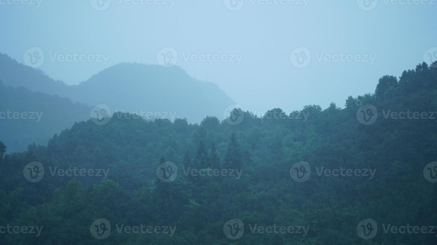 det vackra bergslandskapet med den gröna skogen och den lilla byn som bakgrund på Kinas landsbygd foto