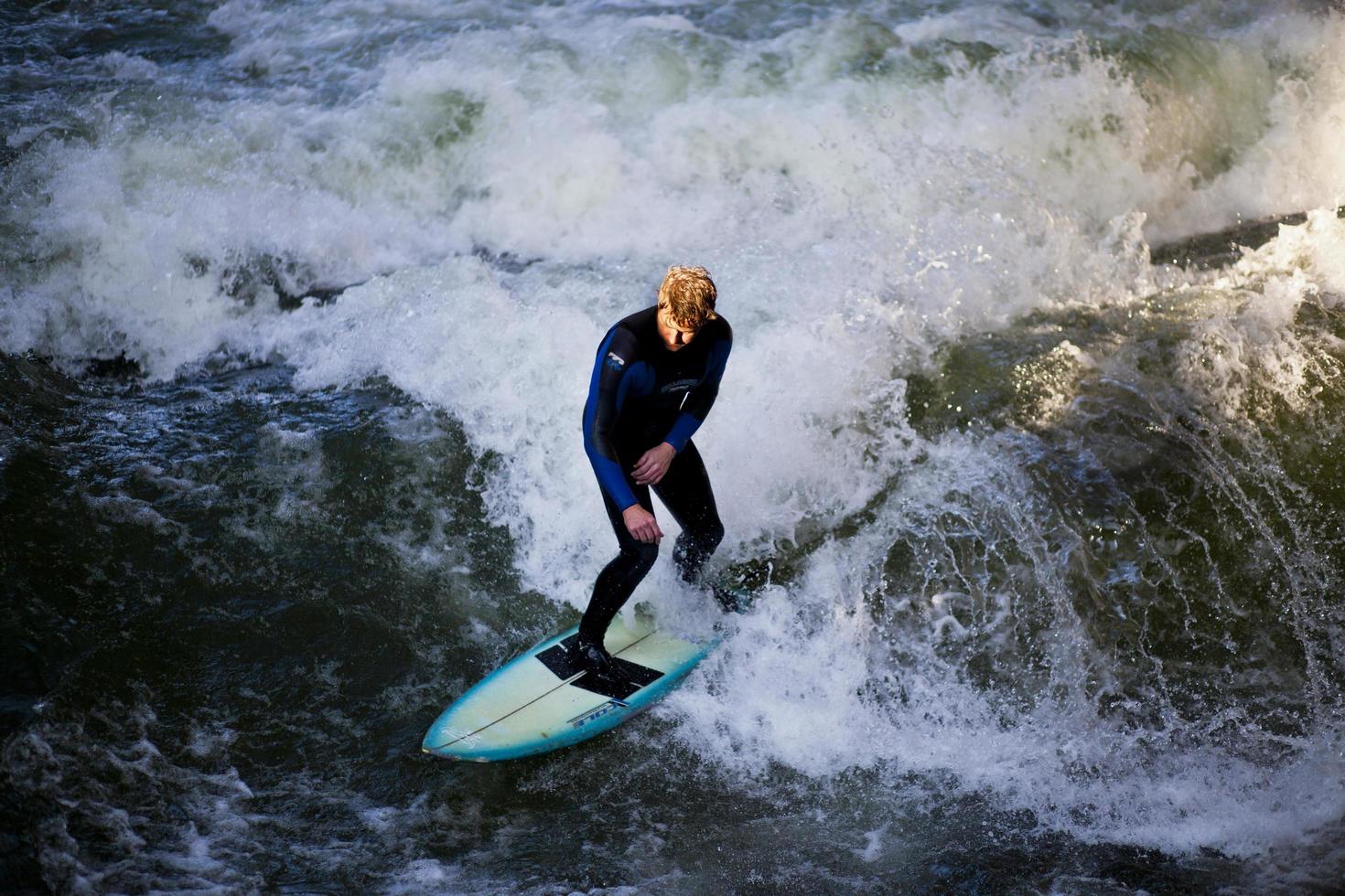 München, Tyskland - 23 oktober 2011 - oidentifierad surfare i eisbachfloden i engelsk trädgård i München, Tyskland den 23 oktober 2011. de första surfarna upptäckte eisbach på 1970-talet. foto