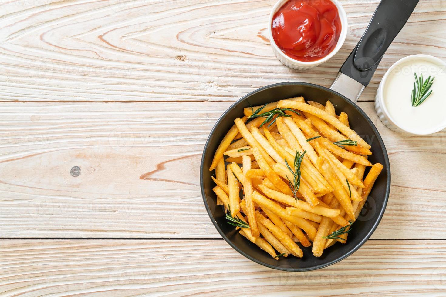 pommes frites med gräddfil och ketchup foto