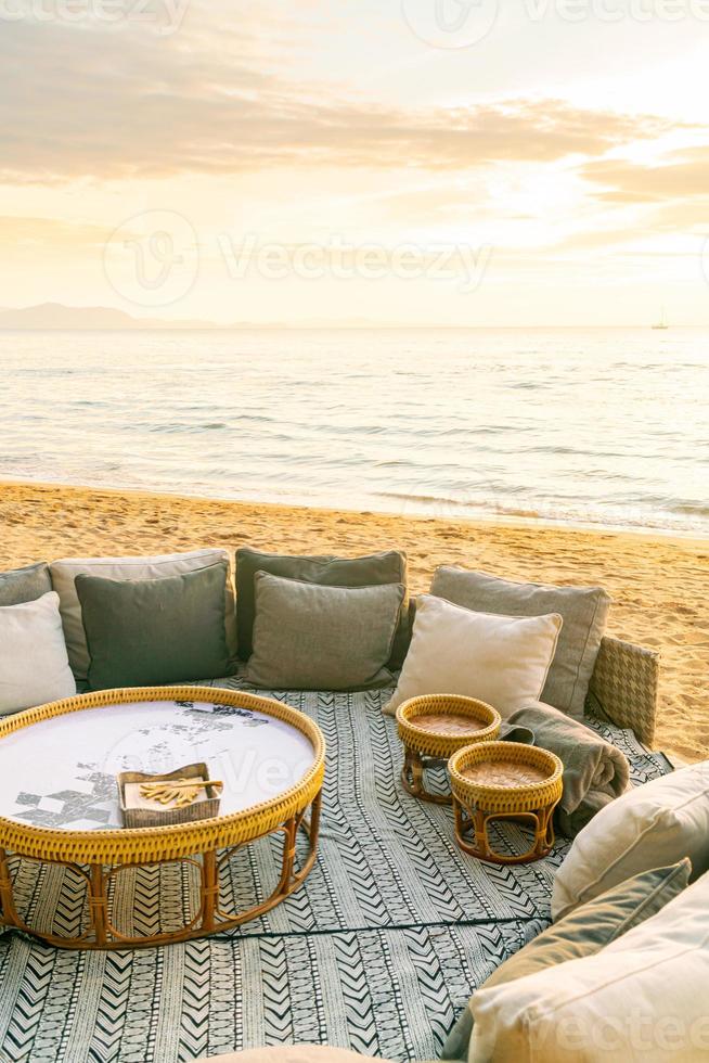 kuddar på uteplats solstol på stranden med solnedgångstider foto