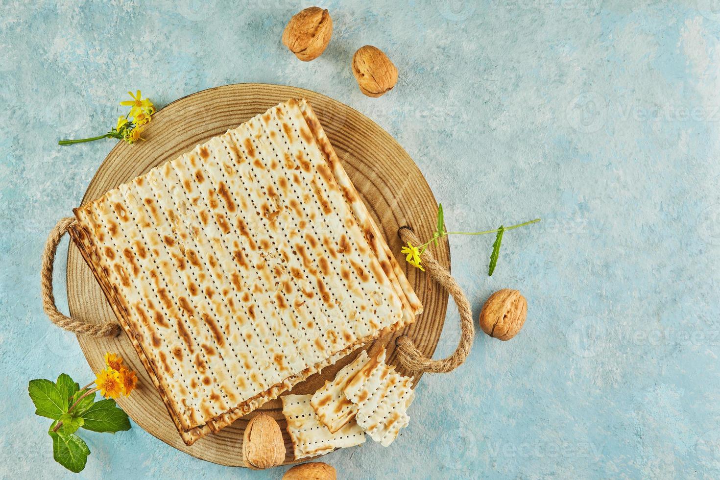 pesach firande koncept - judiska påskhelgen. matzah på träställning med nötter och vilda blommor foto