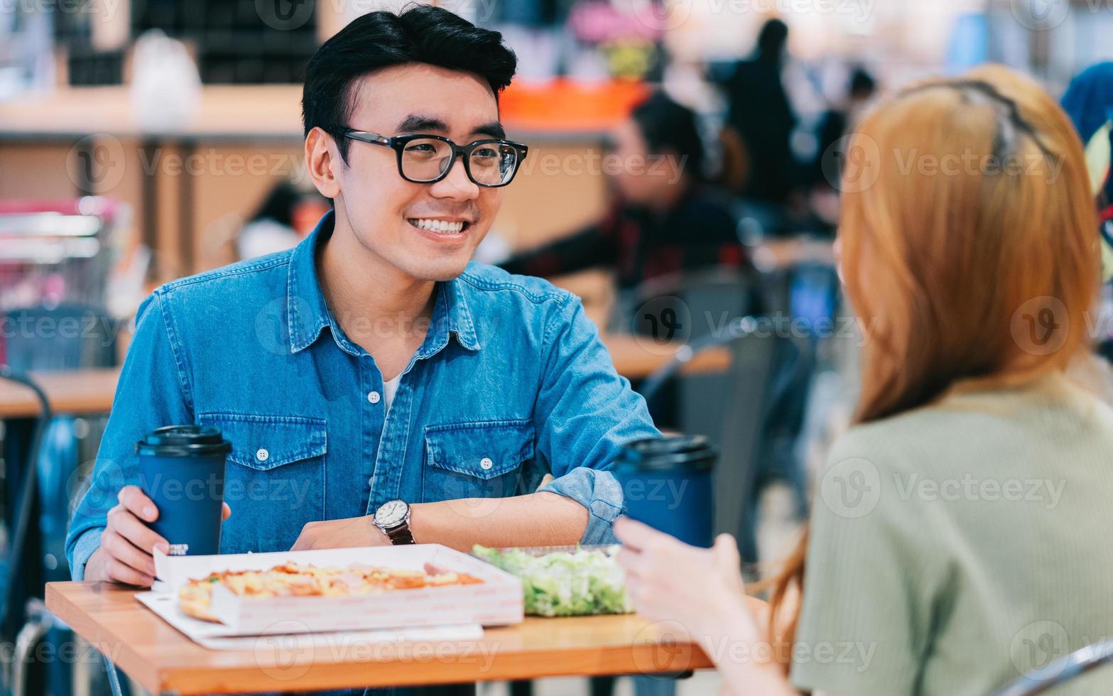 ungt asiatiskt par äter lunch tillsammans i café foto