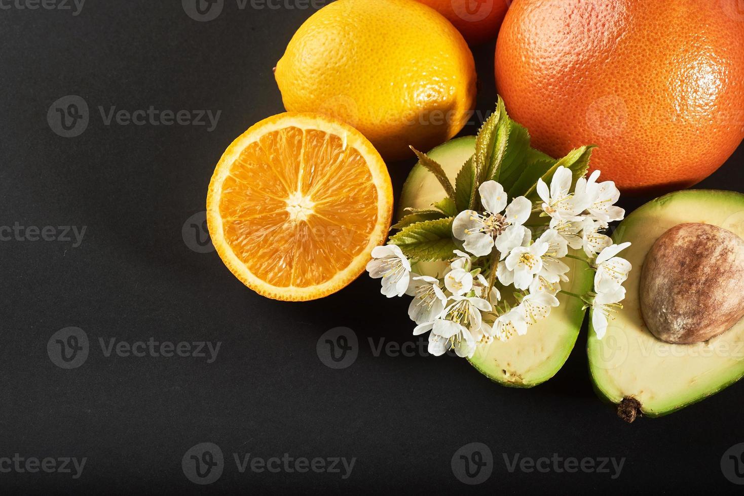 grapefrukt, apelsin och avokado, isolerad på en svart bakgrund foto