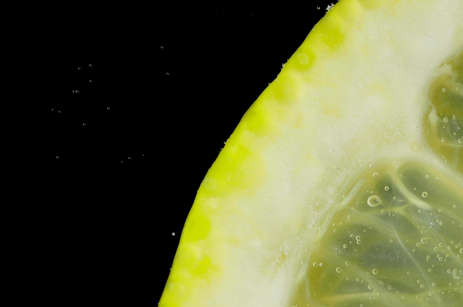 citron i vatten med bubblor detaljvy foto