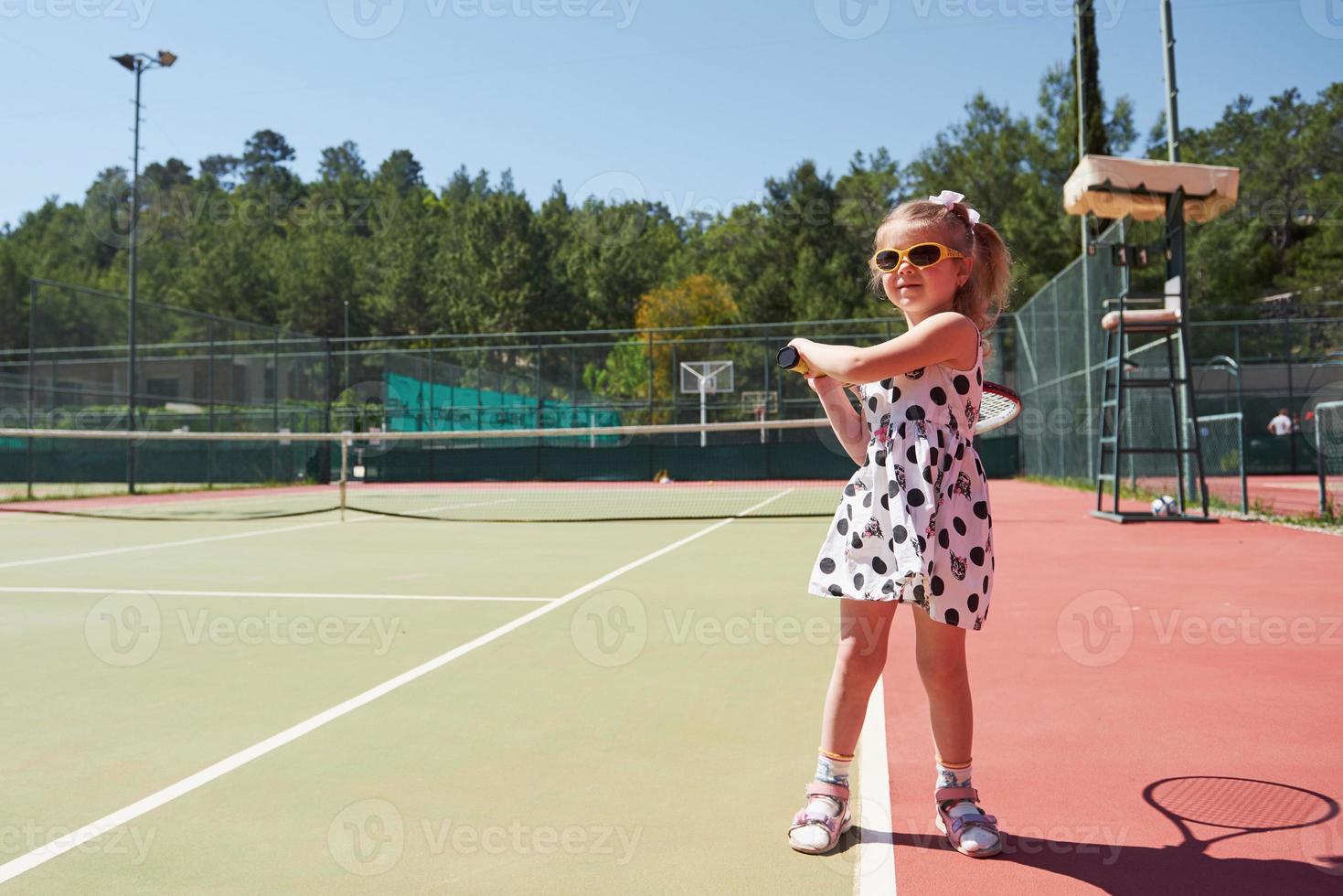 glad liten flicka spelar tennis foto