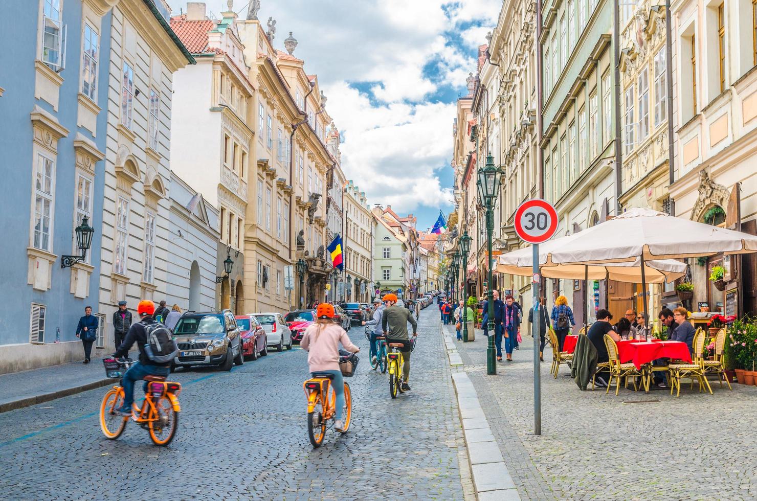 Prag, Tjeckien, 13 maj 2019 människor turister cyklar cyklar på kullerstensgatan foto