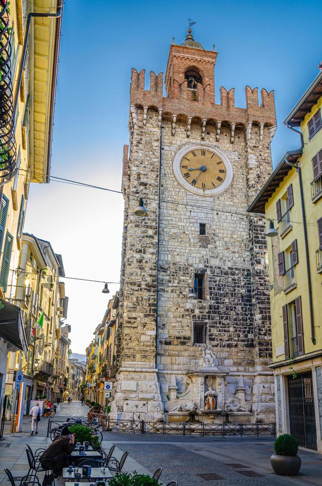 brescia, Italien, 11 september 2019 torre della pallata tegel medeltida klocktorn med merlons i typisk italiensk gata, brescia stad foto