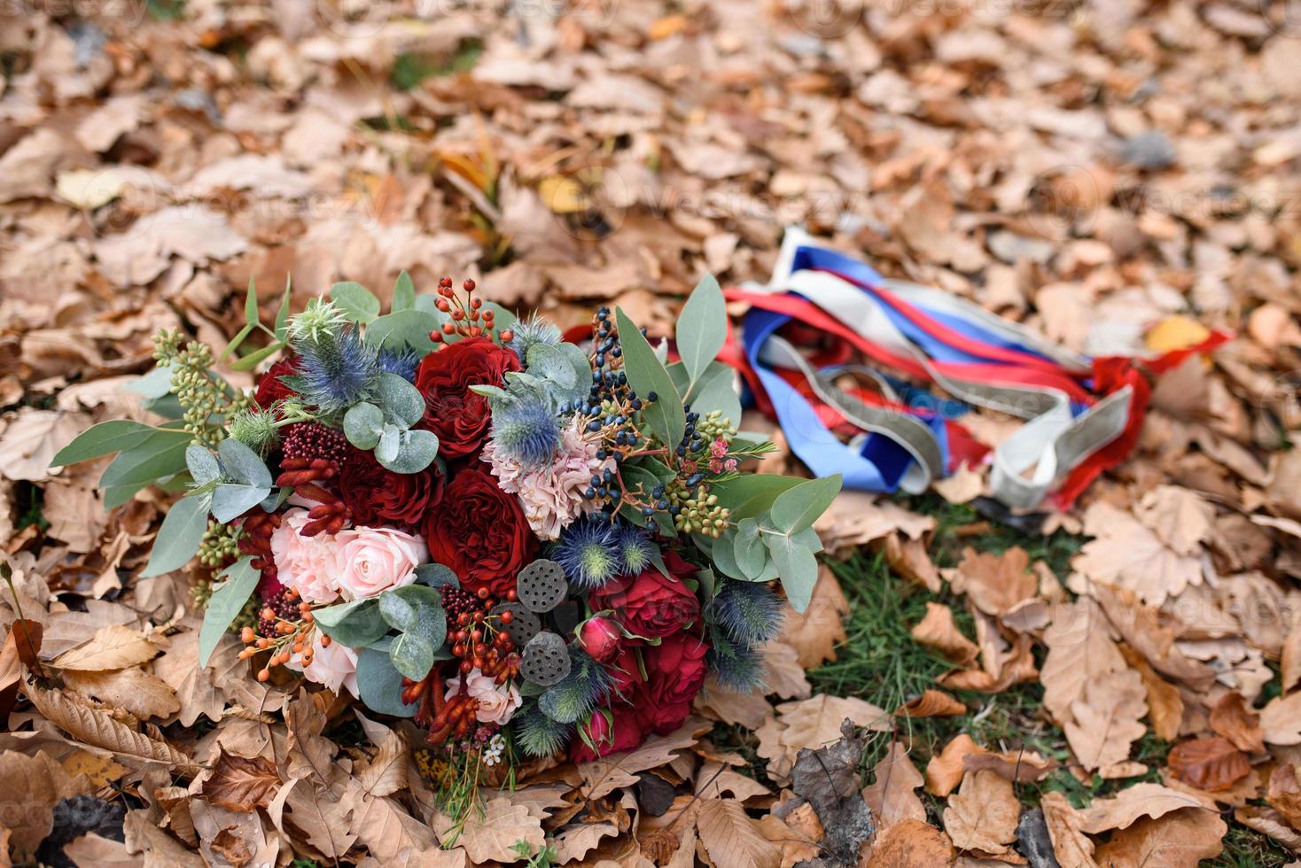 bröllop blombukett ligger på bladverket på hösten foto