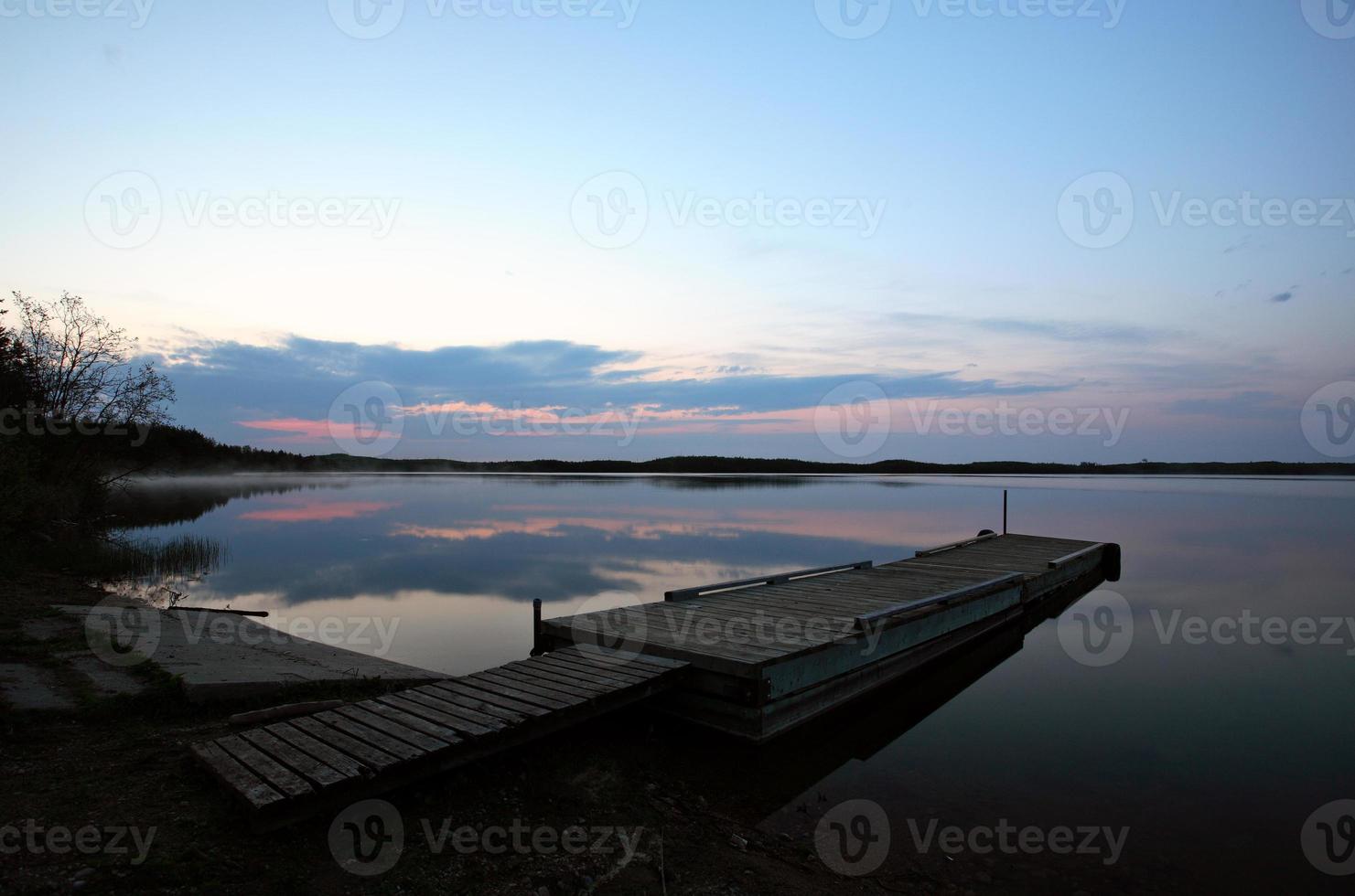 båtbrygga vid småfisksjön i natursköna saskatchewan foto